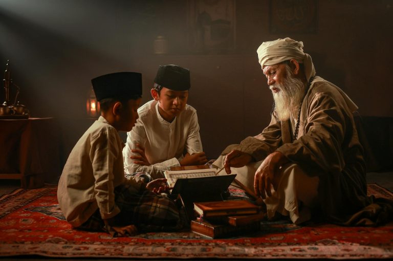 Elderly man teaching two boys in traditional Islamic attire indoors in Jakarta.